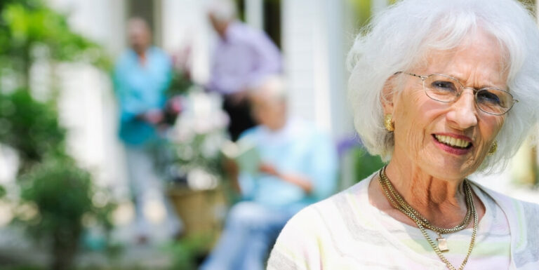 Elderly Woman Smiling in the Garden of an Assisted Living Facility.