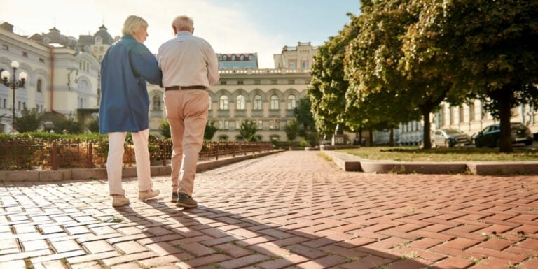 Elderly Couple Walking Together on Independent Living Facility Pathway